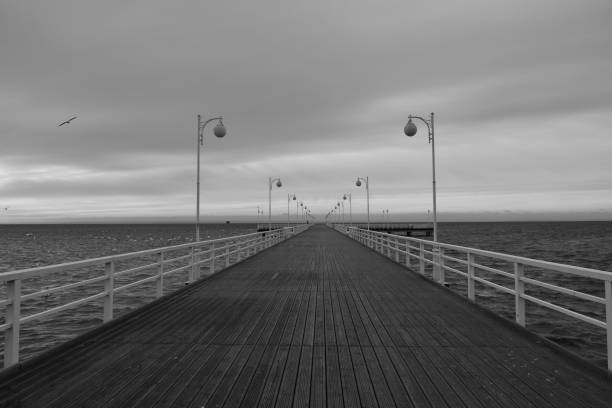 istock Black and white pier extending into the sea 2189342469