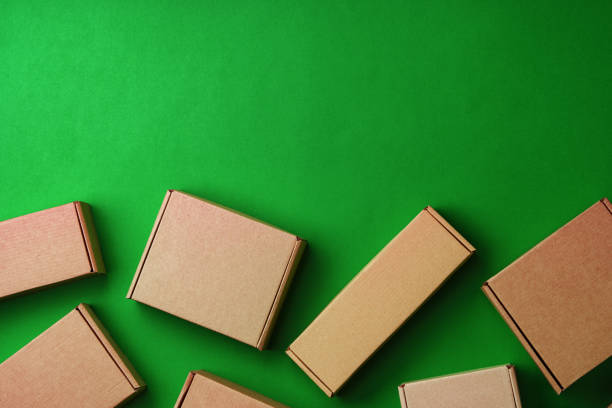 istock Brown cardboard boxes arranged on a vibrant green surface 2189343170