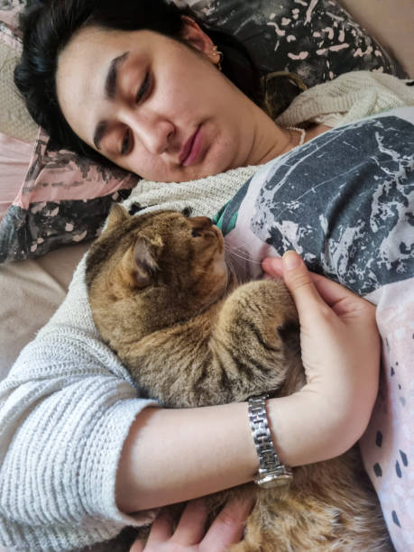 istock Woman with cat lying in bed at home 2189345495