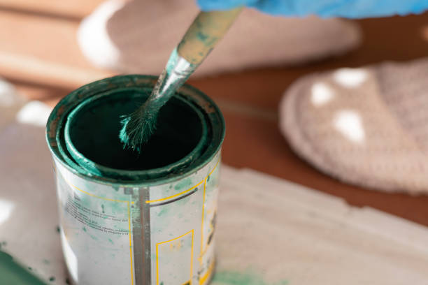 istock Paintbrush dipping into green paint can during a restoration project 2189348849