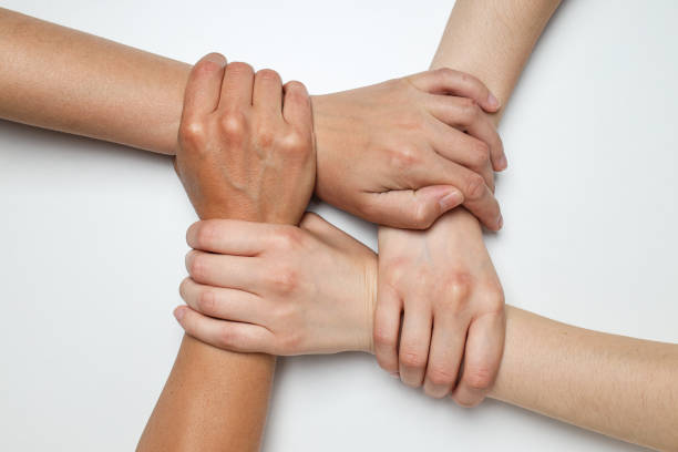 Top view of hands joined in a lock on white background