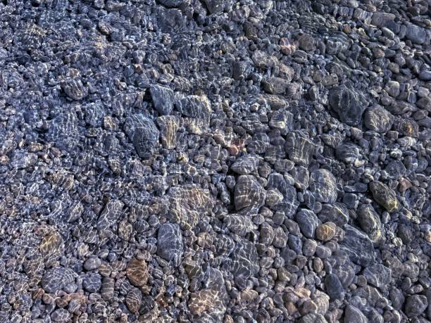 Pebbles and stones in transparent water.
