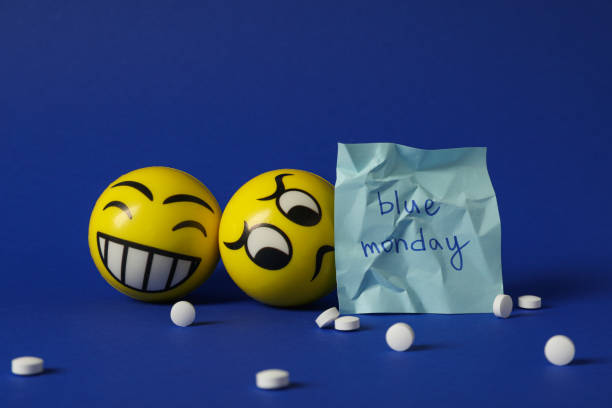 Paper with Blue Monday text, pills and emoji on blue background