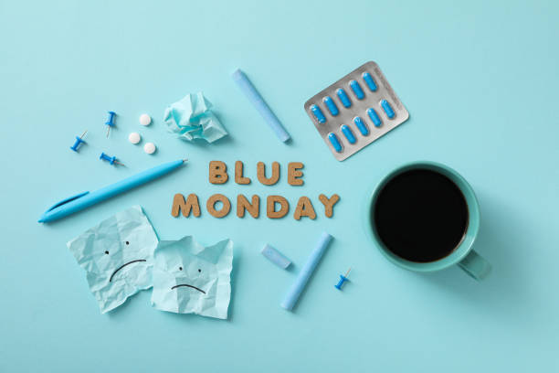 istock Blue Monday text, pills, cup and stationery on blue background, top view 2189354442