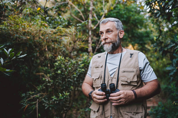istock Portrait of a senior man observing nature with binoculars 2189356718