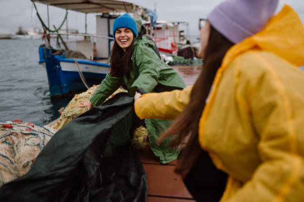 Group of happy volunteers preparing a boat for stormy weather