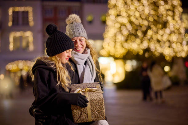 istock Mother and daughter sitting on bench at townhall square 2189358290