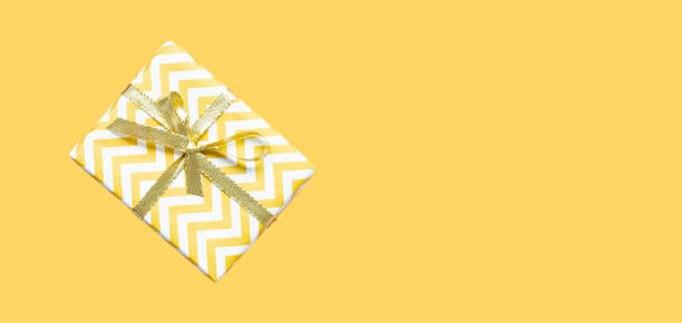 istock Yellow gift box with gold ribbon bow. 2189358831