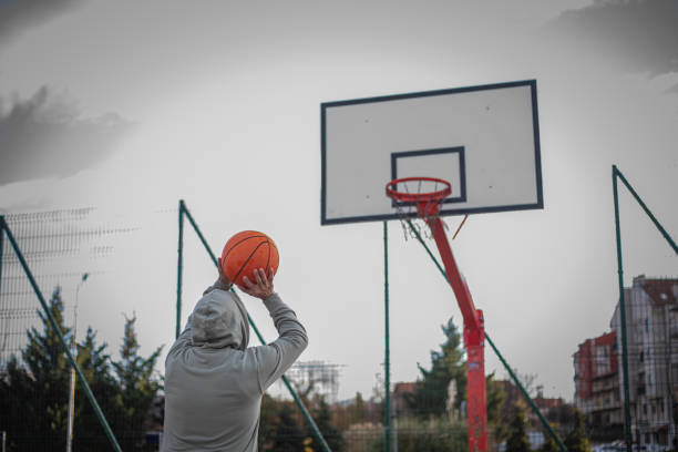 Recreational pursuit, man playing basketball alone