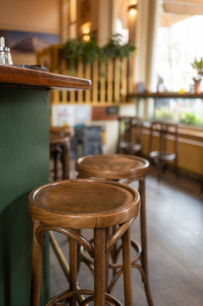istock Empty round wooden stools at bar counter in cafe 2189360705