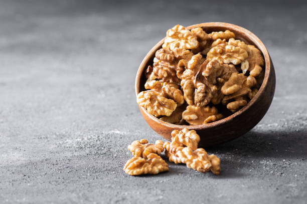 istock Ripe and fresh walnut kernels in bowl or burlap sack without shell on rustic table, healthy nut food for brain 2189360948
