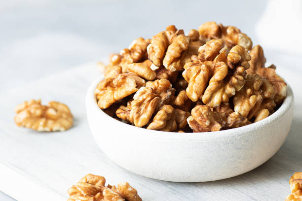 istock Ripe and fresh walnut kernels in bowl or burlap sack without shell on rustic table, healthy nut food for brain 2189360972