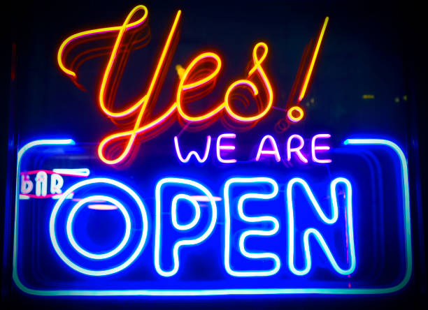 istock Yes, we're open - glowing neon sign board on glass window during night time 2189362458