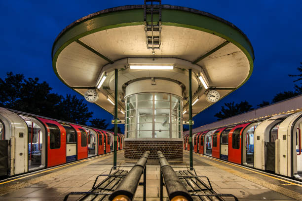 Evening at the urban train station with bright lights and passing trains