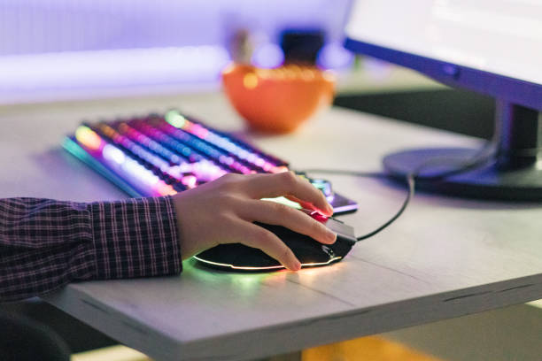 istock Close-up of boy's hands while playing computer games with RGB computer keyboard and mouse. Children gaming addiction. 2189366457