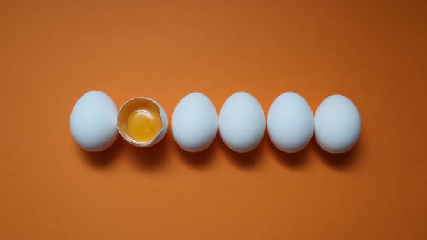 istock Row White eggs and egg yolk on the yellow background. 2189366556