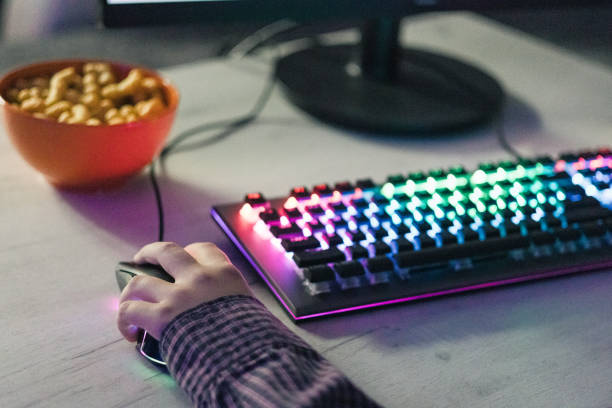 istock Close-up of boy's hands while playing computer games with RGB computer keyboard and mouse. Children gaming addiction. 2189367261