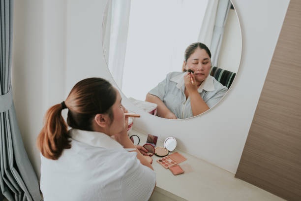 istock Make up face,Asian plus size woman applying make-up in front of mirror everyday make up before going to work 2189367733