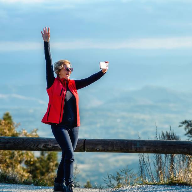 Happy woman taking a selfie on top