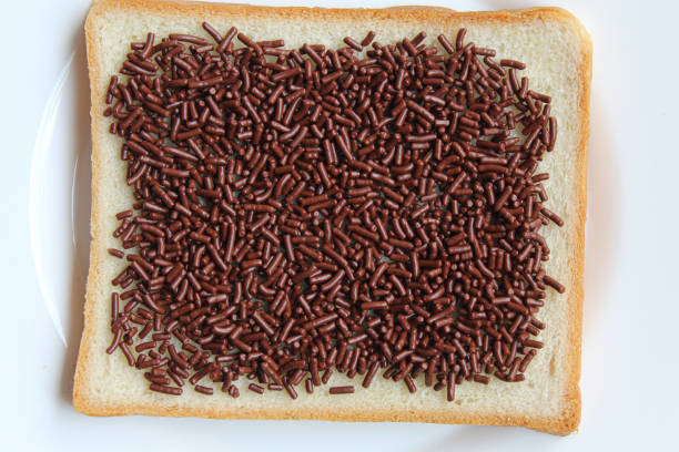 istock One slice of white square bread, with chocolate sprinkles spread, on white plate, isolated on white background, flat lay or top view 2189373420