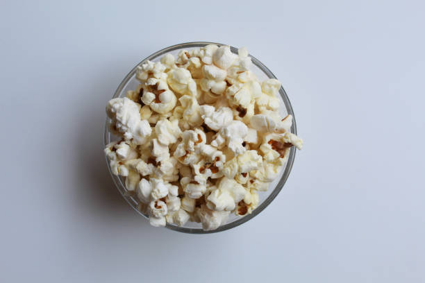 istock Plain popcorn in transparent glass bowl, isolated on white background, flat lay or top view 2189373716
