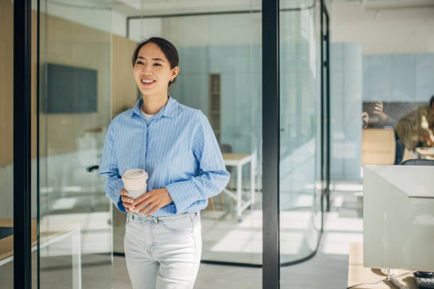 istock Smiling woman with coffee in a creative office 2189374205