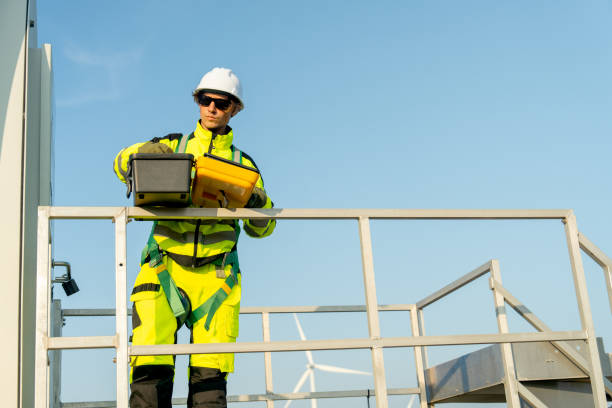 istock Front view of wind turbine worker or technician man stand on base of windmill and check tools in the toolsbox with day light. 2189377454