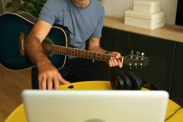 istock A man sitting in front of the computer practicing online music lessons 2189378995