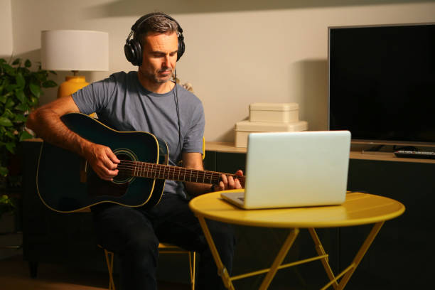 istock A man sitting in front of the computer practicing online music lessons 2189379061
