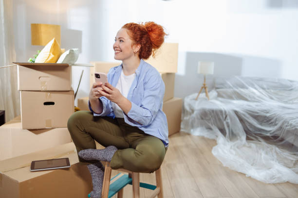 istock Woman relaxing in home surrounded by moving boxes and unpacked items 2189379270