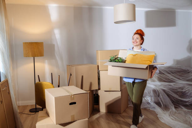 istock Woman carrying boxes while moving into a new home 2189379385