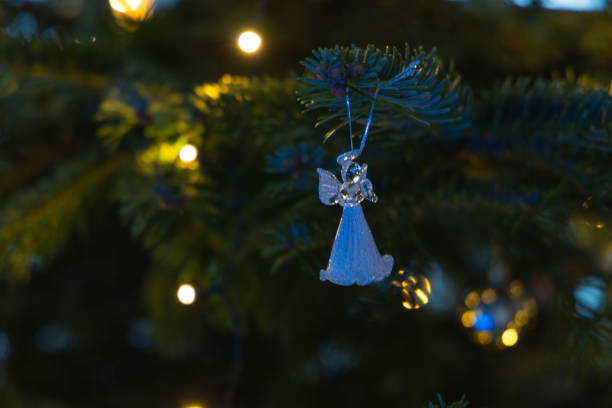 white christmas decoration on a tree branch. christmas tree with lights. christmas tree toy.