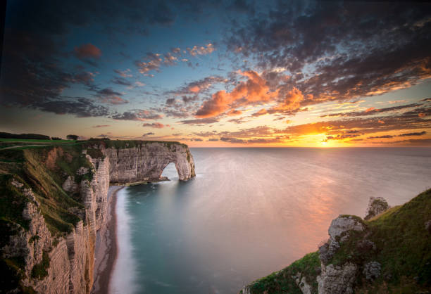 istock Stunning sunset over the dramatic cliffs and arch at Etretat, France during evening hours 2189383318