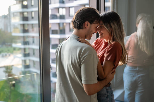 istock Couple in love embracing by the window 2189383921