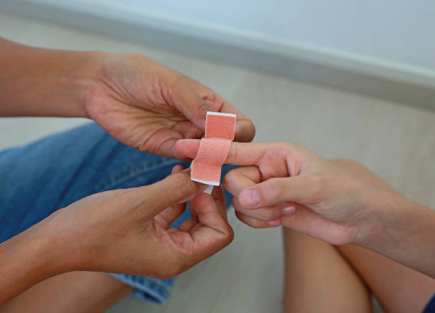 istock Close-up hands mother applying bandage to the child's wound. 2189384689