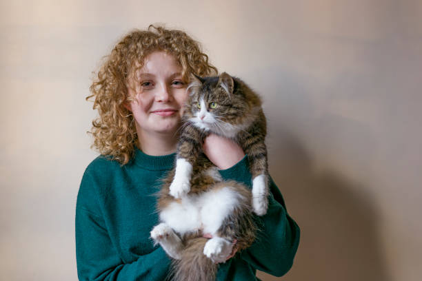 istock Smiling girl holding fluffy cat indoors 2189394307