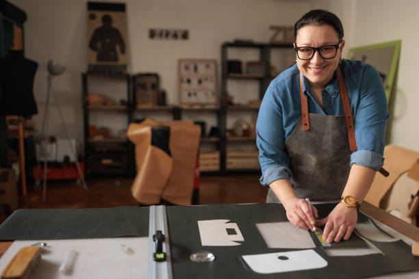 istock Craftswoman Cutting Leather for Custom Design 2189394796