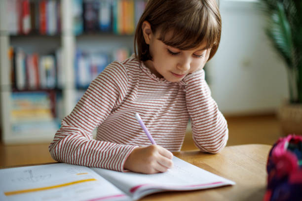 istock Cute little girl doing homework 2189398790