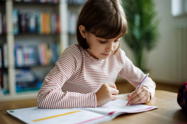istock Cute little girl doing homework 2189398839