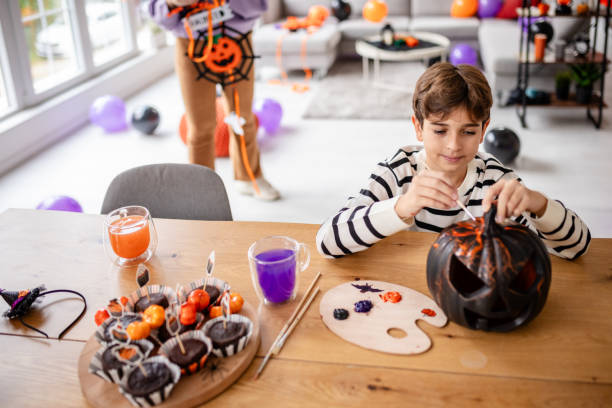 istock Kid Carving a Pumpkin for Halloween Decorations 2189399384