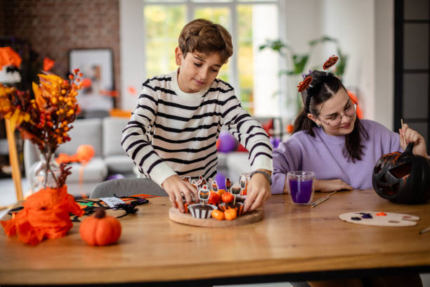 istock Child Decorating Table with Festive Halloween Treats 2189400574
