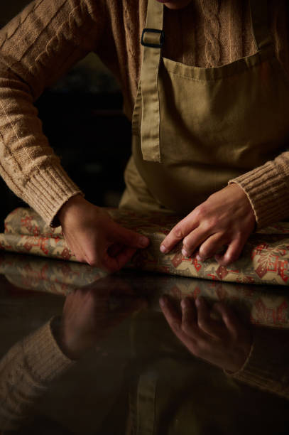 istock Close-up Wrapping Gift in Festive Paper on Reflective Surface 2189403698