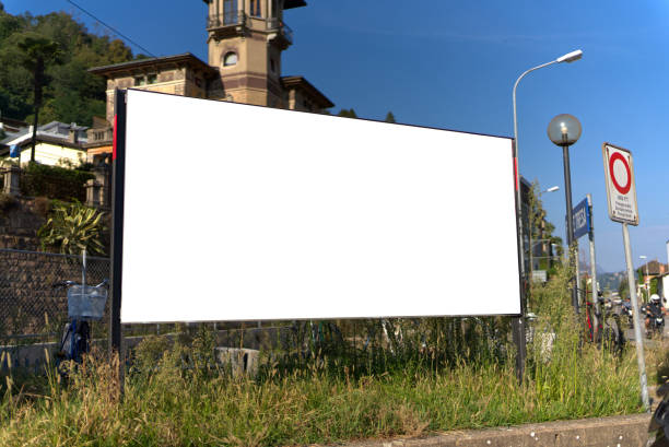advertising banner billboard by the road on a black pole. stretched canvas plastic tarp with advertising message tied strings on the back. black giant advertising stand where rent is paid