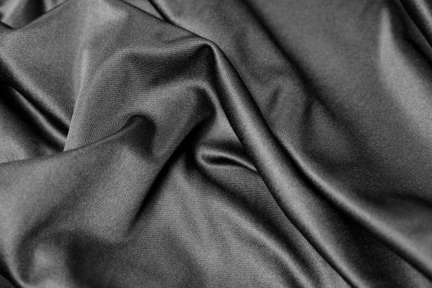 istock black wrinkled fabric texture background, black cloth with ripples and waves background 2189406537