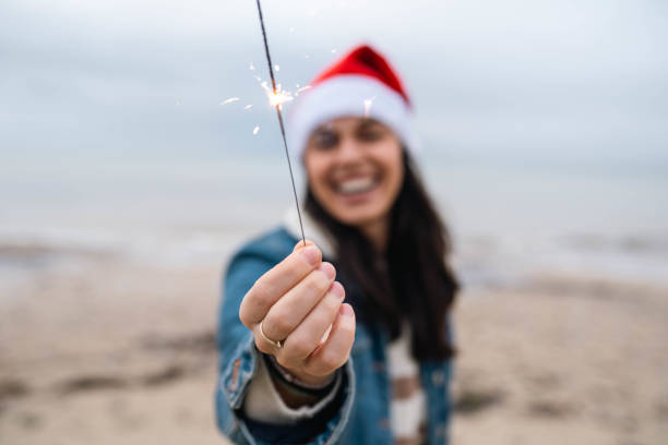 Young smiling woman with a Santa hat at the beach