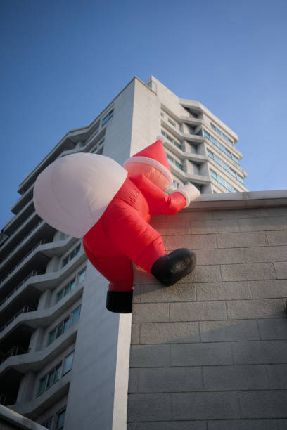 istock Santa claus balloon climbing on a building 2189410784