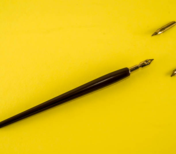 istock A pen with a gold tip sits on a yellow background 2189416967