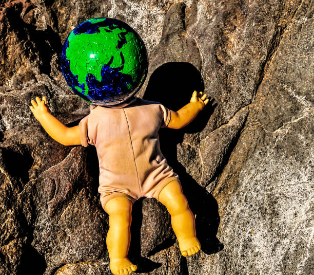 istock A doll with a head made of a globe sits on a rock 2189417059