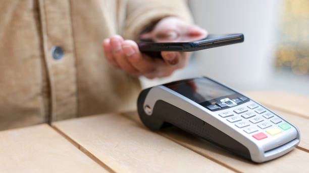 istock Person using smartphone to make a contactless payment on a pos terminal 2189418122