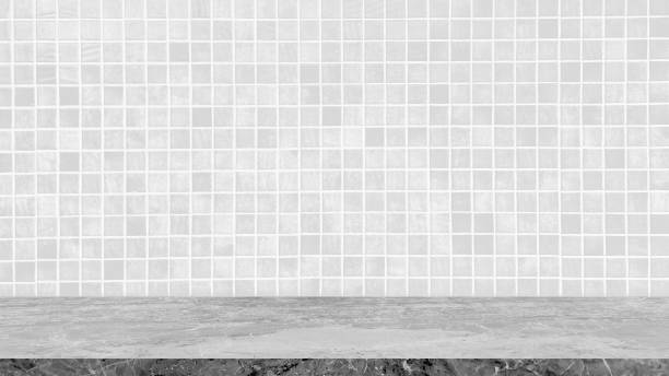 istock empty light grey marble table top in foreground with square white, grey mosaic tile at background. counter bar scene can be used for display or montage products. 2189418220